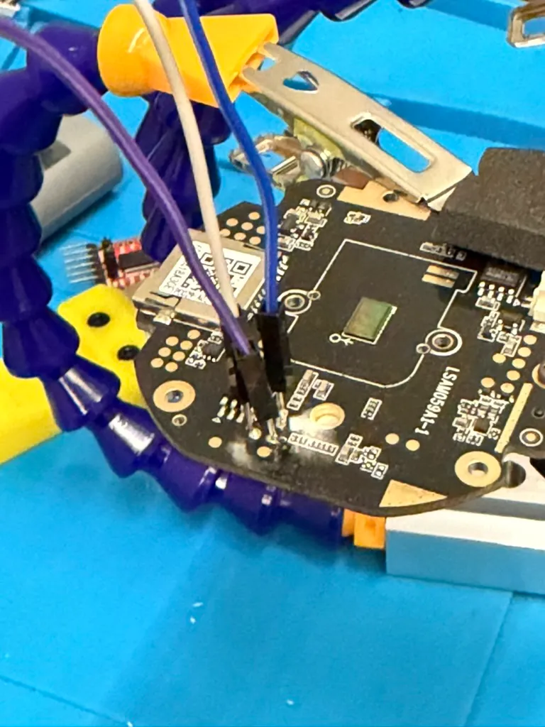 The board in a third hand, flying leads soldered onto the pads