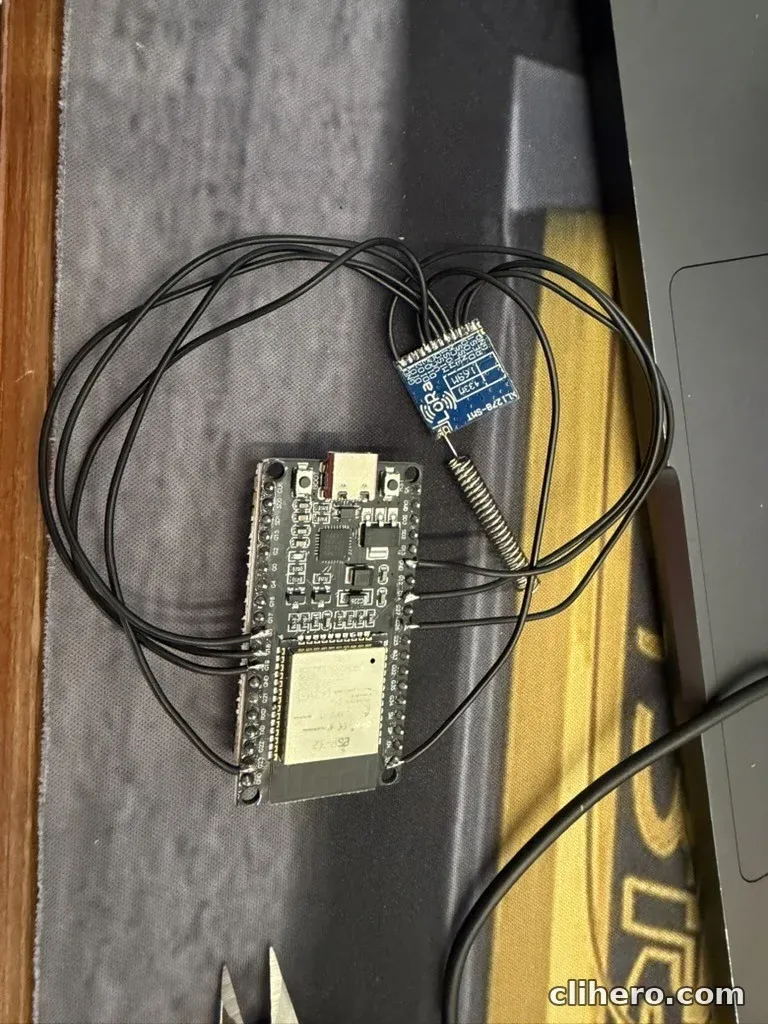 The ESP32 dev board wired to the LoRa module with thin black wires, the spring antenna already soldered to the module